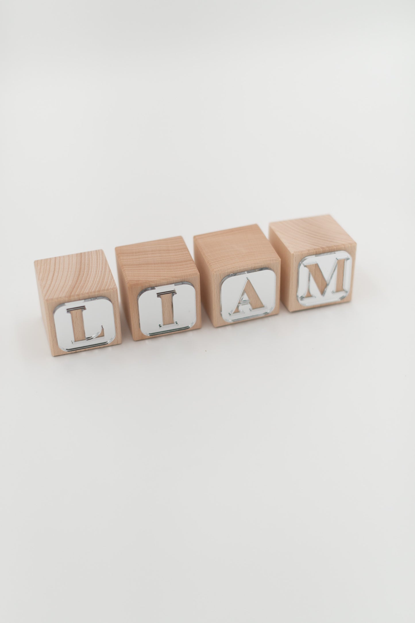 Der Name LIAM gelegt aus Holzwürfeln mit silbernen Buchstaben