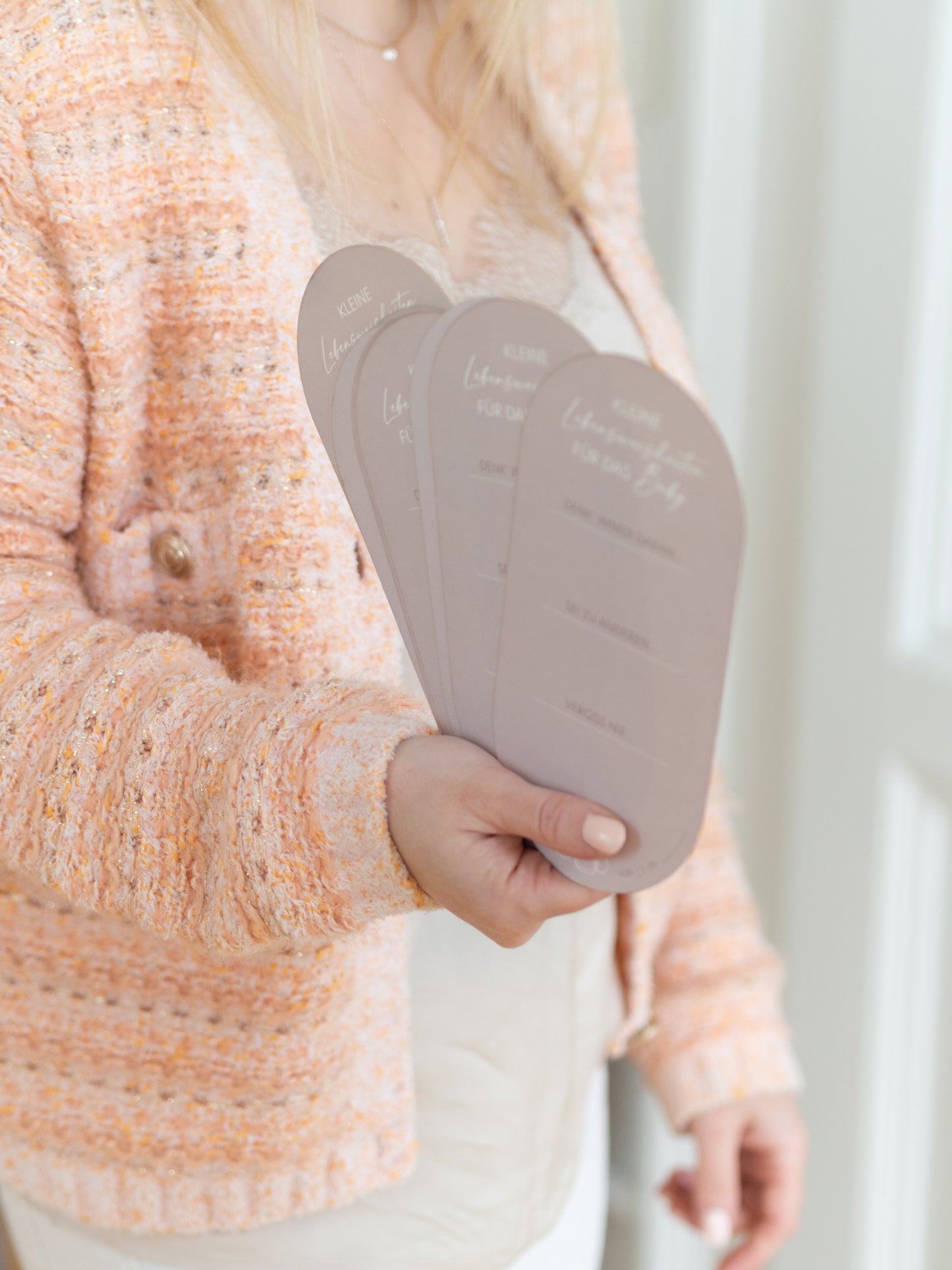 Hand hält Gästebuchkarten mit Lebensweisheiten für das Baby