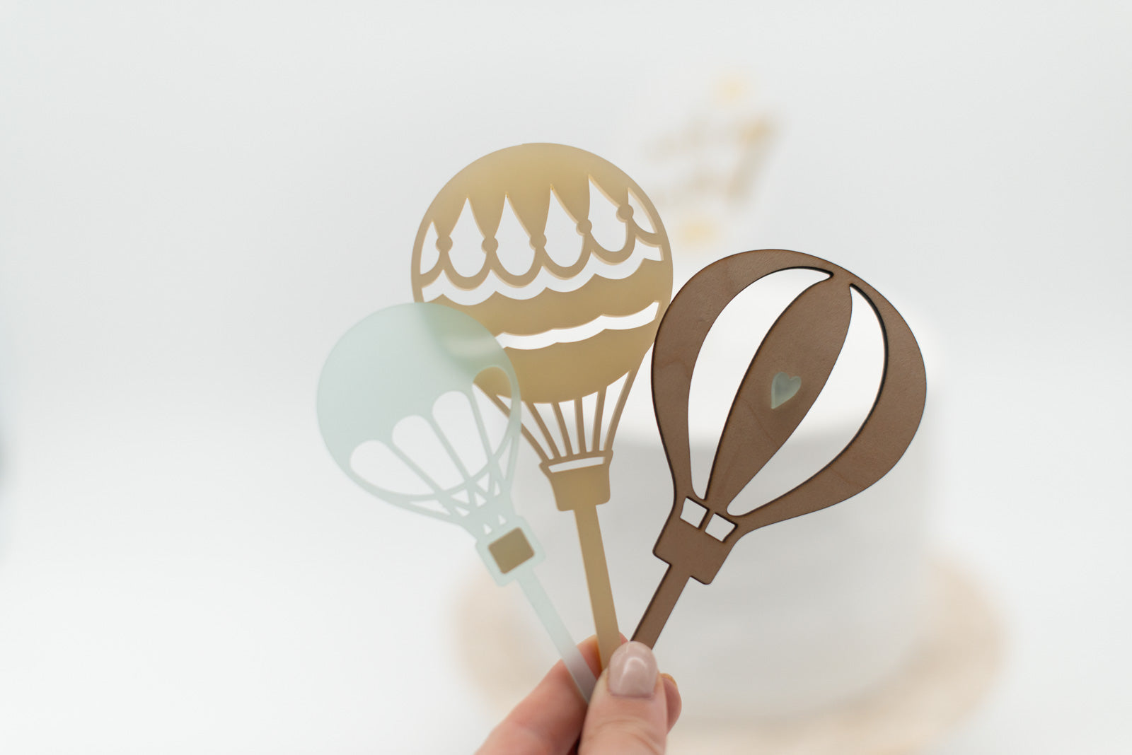 Hand hält Heissluftballon Caketopper Set bestehend aus 3 unterschiedlichen Heissluftballons