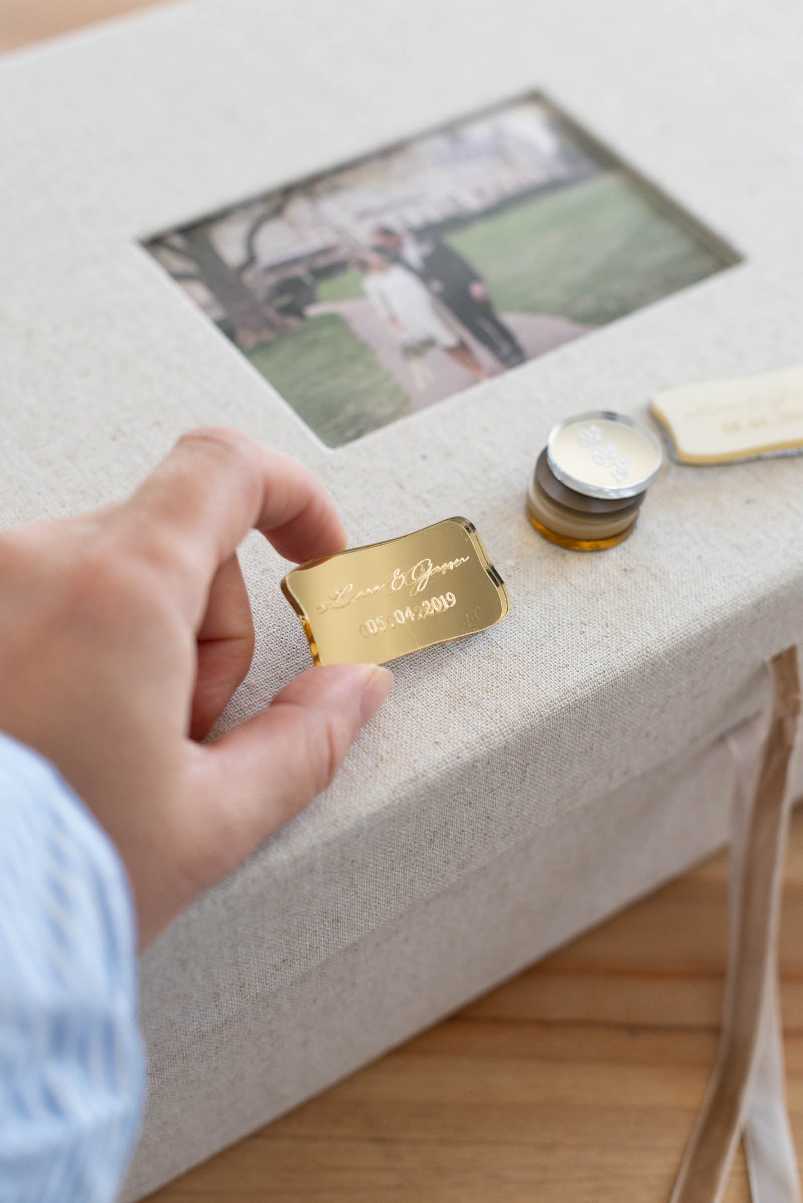 Hand hält personalisiertes goldenes Schild für eine Leinen Erinnerungskiste