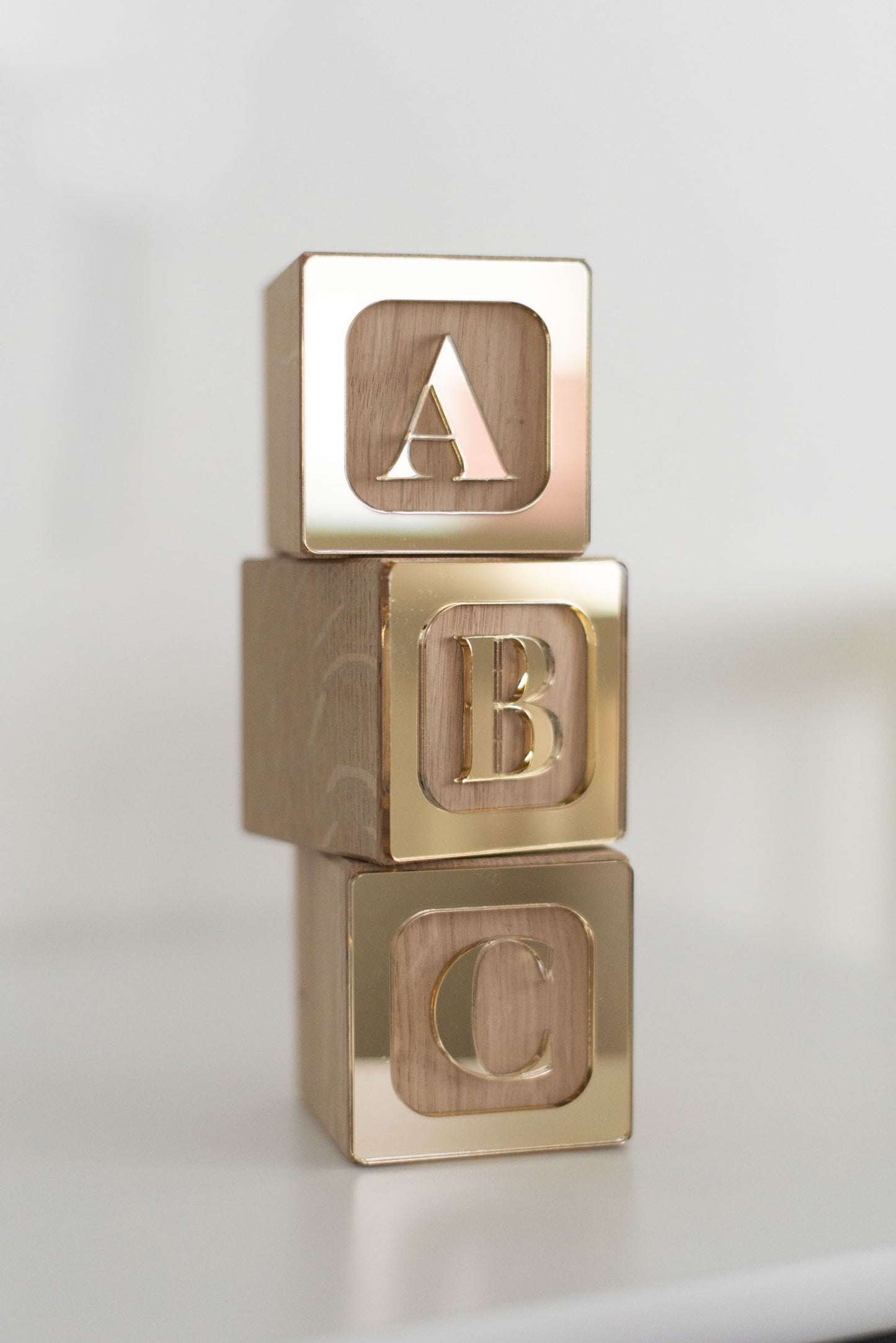 Turm aus Holzwürfeln mit den goldenen Buchstaben ABC aufeinander gestapelt